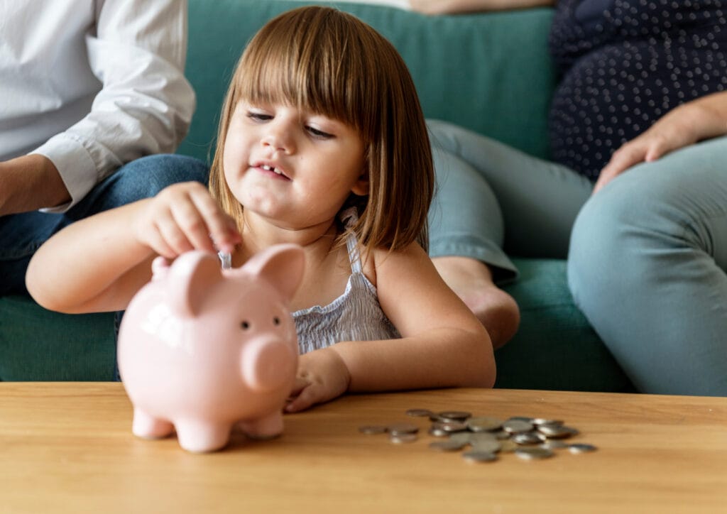 child support - a child putting money into a piggy bank