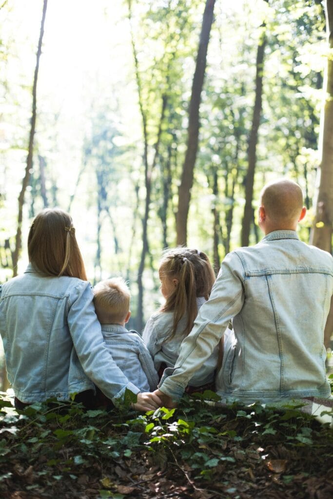 collaborative family law family of 4 sitting in the forest peacefully holding hands