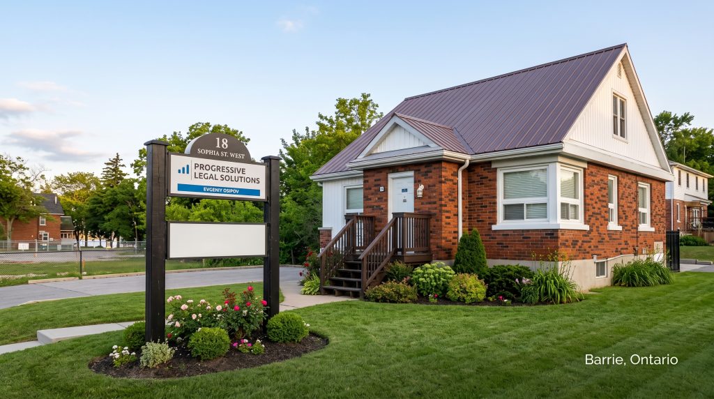 Exterior view of the Progressive Legal Solutions office at 18 Sophia St. West in Barrie, Ontario, showing a red brick building and a business sign on a green lawn